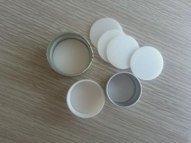 Various rubber liners are prepared to be inserted into bottle caps, helping to seal the bottles and preserve the drink's quality.