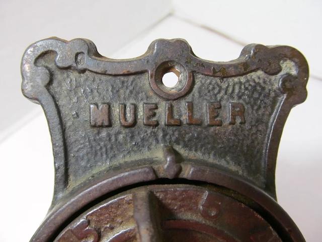 The embossed "Mueller" logo on this furnace plate emphasizes the craftsmanship and brand recognition of this vintage heating equipment.
