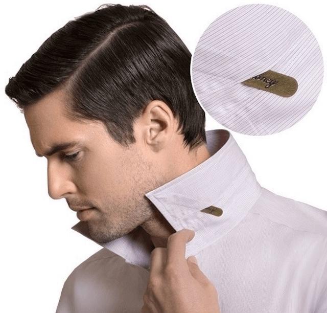 Close-up of collar stay in place inside a man's white dress shirt collar, with the stay marked for authenticity.