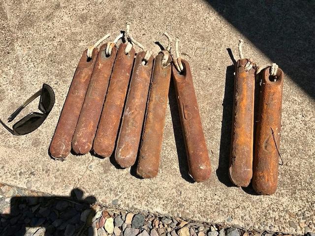 A collection of window sash weights from the early 20th century, each one telling the story of homes from the past where they ensured smooth window operation.