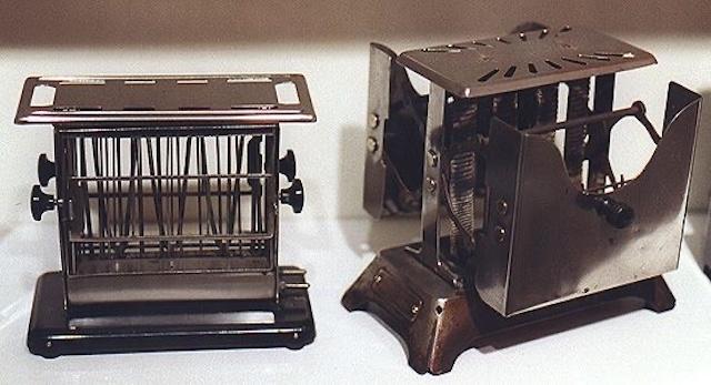 A pair of vintage toasters side by side, representing different designs from an era when kitchen technology was just beginning to take shape.
