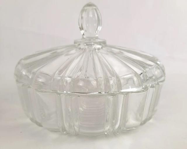 A closer look at the vintage glass candy dish, with its intricate ribbed design and knobbed lid, crafted to keep precious sweets hidden… albeit not too quietly!
