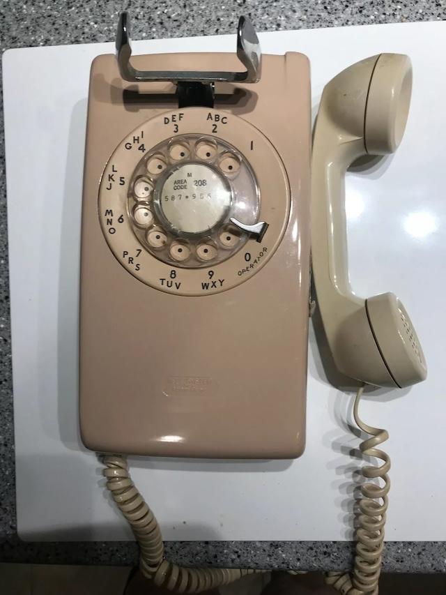 The rotary dial on this wall-mounted rotary phone adds a touch of nostalgia, reminding us of a time before digital numbers ruled the world