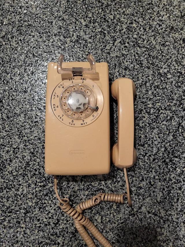 This vintage rotary phone 554 comes with its original handset and coiled cord, perfectly preserved in a beautiful beige color