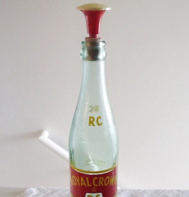 An old sprinkler bottle top attached to a vintage RC bottle, showing how everyday bottles were repurposed with this cap for ironing purposes
