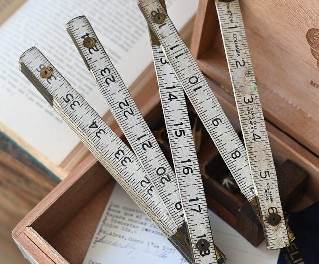 A well-used folding wooden ruler, its joints still flexible, reminding us of a time when simplicity and utility went hand in hand