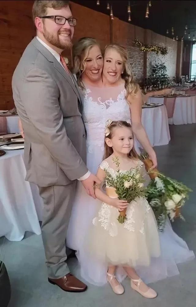 A touching family moment: Abby and Brittany with their husband and daughter, celebrating love
