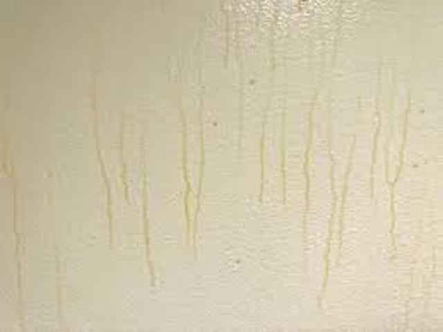 Multiple yellow trails on a pale surface, possibly caused by condensation, smoke residue, or chemical reactions