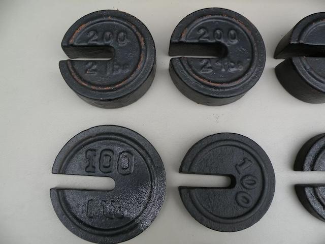 A collection of vintage scale weights with distinctive markings, reflecting the quality craftsmanship of their time