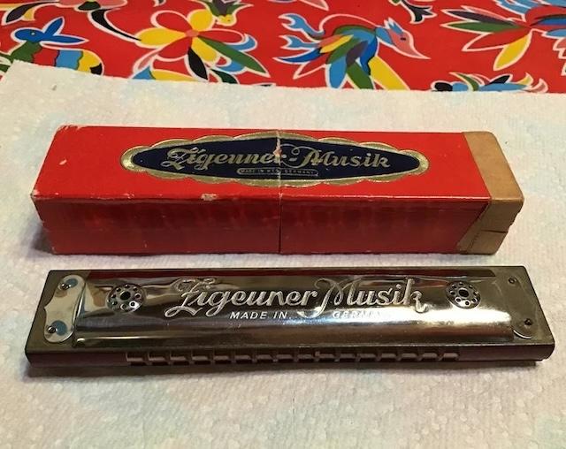 Nestled alongside its original packaging, this vintage harmonica embodies the spirit of musical creativity from a bygone era