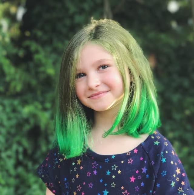 Temporary fun or a step too far? Her green-dipped hair might be trendy, but it raises important questions about childhood innocence