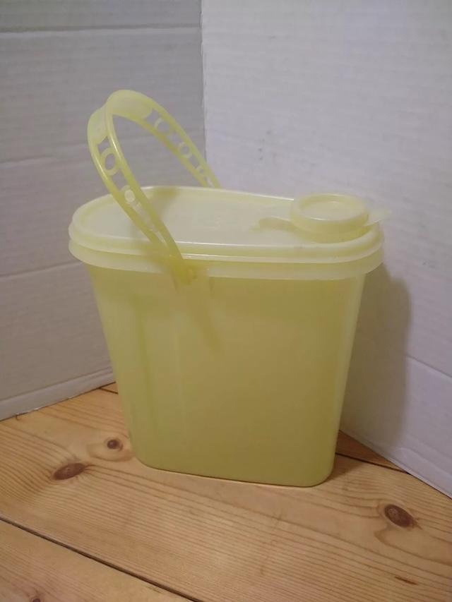 With its cheerful yellow hue and iconic sturdy handle, this vintage 1970 Tupperware carrier stood the test of time, perfect for family picnics and outdoor gatherings