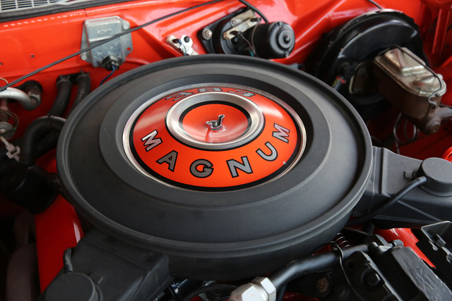 A close-up of the 1970 Dodge Challenger R/T’s Magnum engine air filter, clearly marked with the iconic red and black colors that emphasize the muscle car’s performance focus.