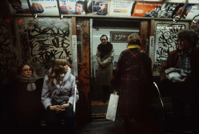 A man, on the verge of boarding a subway car, stands at the threshold of the city’s lifeblood, ready to dive back into New York's vibrant pulse.
