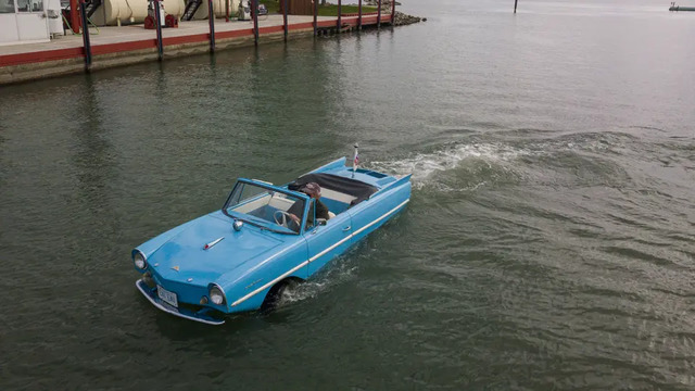The Amphicar Model 770 cruising on the water, showcasing its amphibious capabilities.