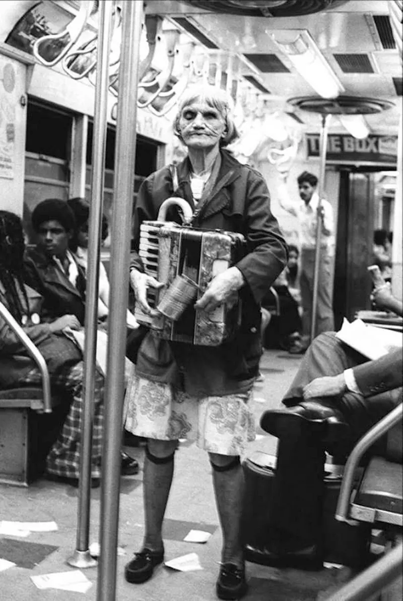 An elderly woman plays the accordion for spare change on the subway—a testament to survival in hard times. Photograph by Leland Bobbé.