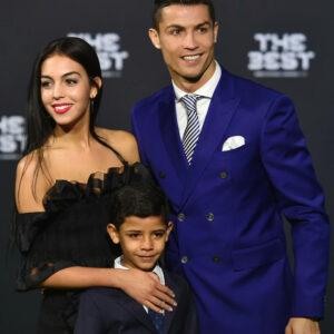 Cristiano Ronaldo, Georgina Rodríguez, and their son pose at an event.