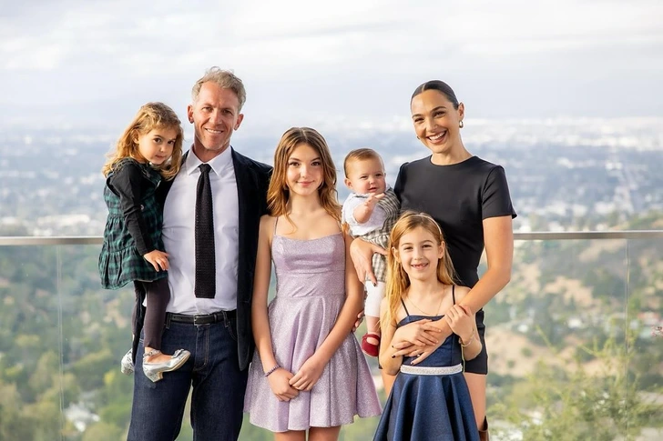 Gal Gadot and her family posing for a stunning family photo.