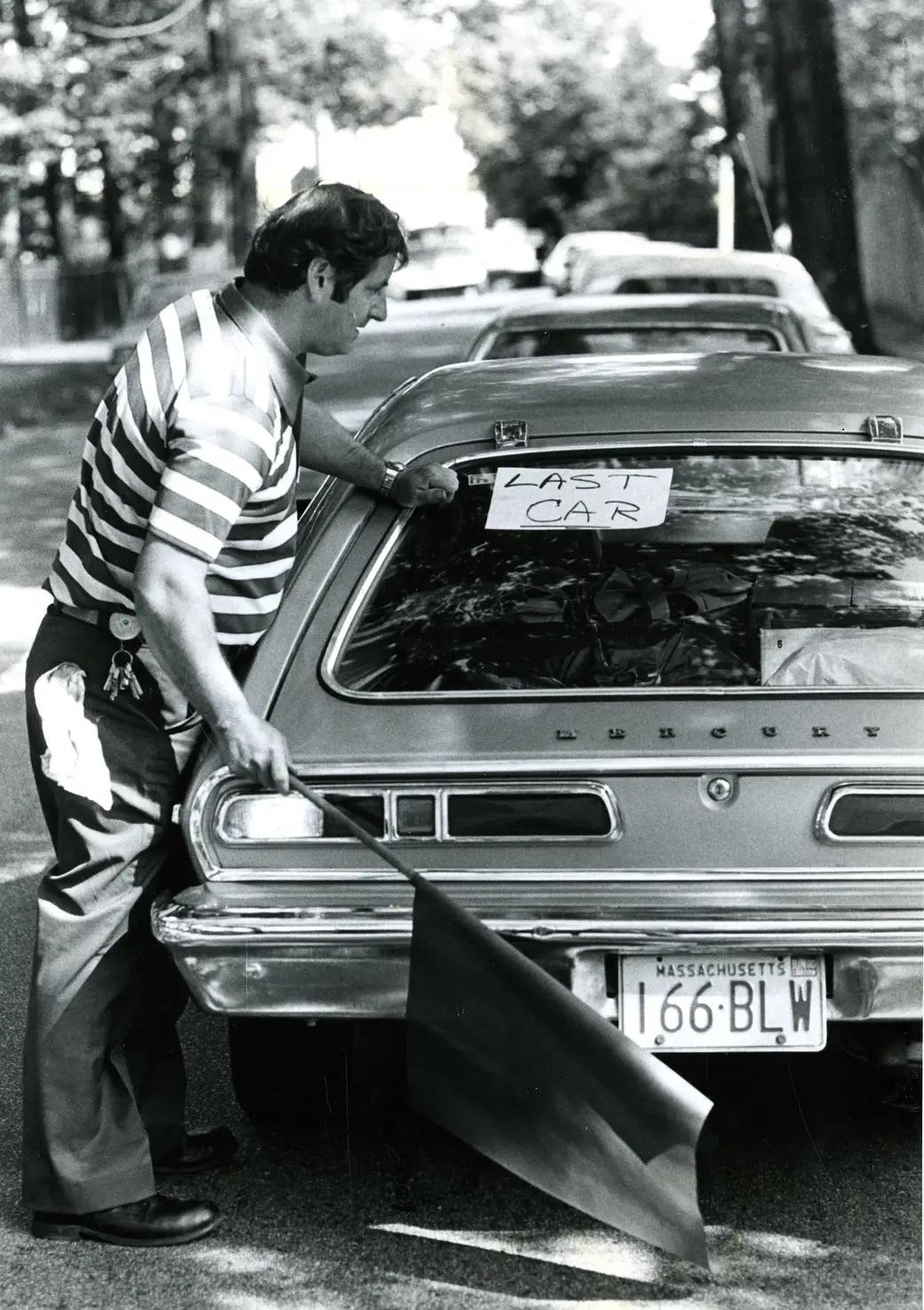 On June 25, 1979, at a Chestnut Hill Texaco, Ron Clancy waves a red flag and posts a "last car" sign on the final vehicle—a bold moment amid the fuel crisis