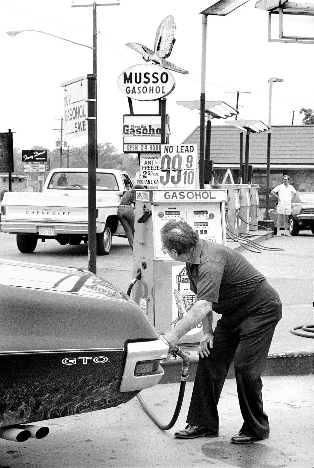 In July 1979, a man pumps gas at a station—a simple act that encapsulates the era's unique challenges and spirit