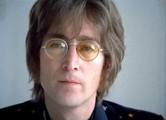 A striking black-and-white image of John Lennon, capturing his intellectual and artistic vibe during his solo years.