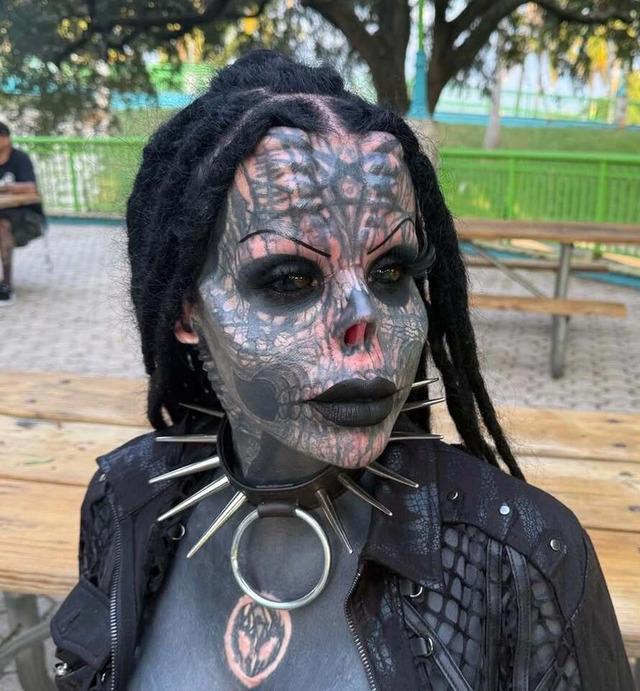Another angle of Toxii, highlighting her dramatic body modifications, including the spiked collar and eye-catching tattoos.