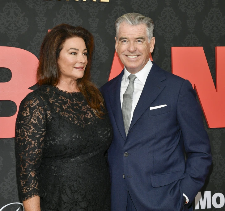 Keely exudes grace and beauty, wearing a stunning black lace dress as she stands proudly beside her husband Pierce.