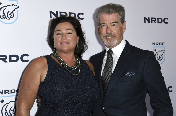 Keely’s elegant look in a navy dress complements Pierce’s distinguished appearance, highlighting their strong and enduring relationship.