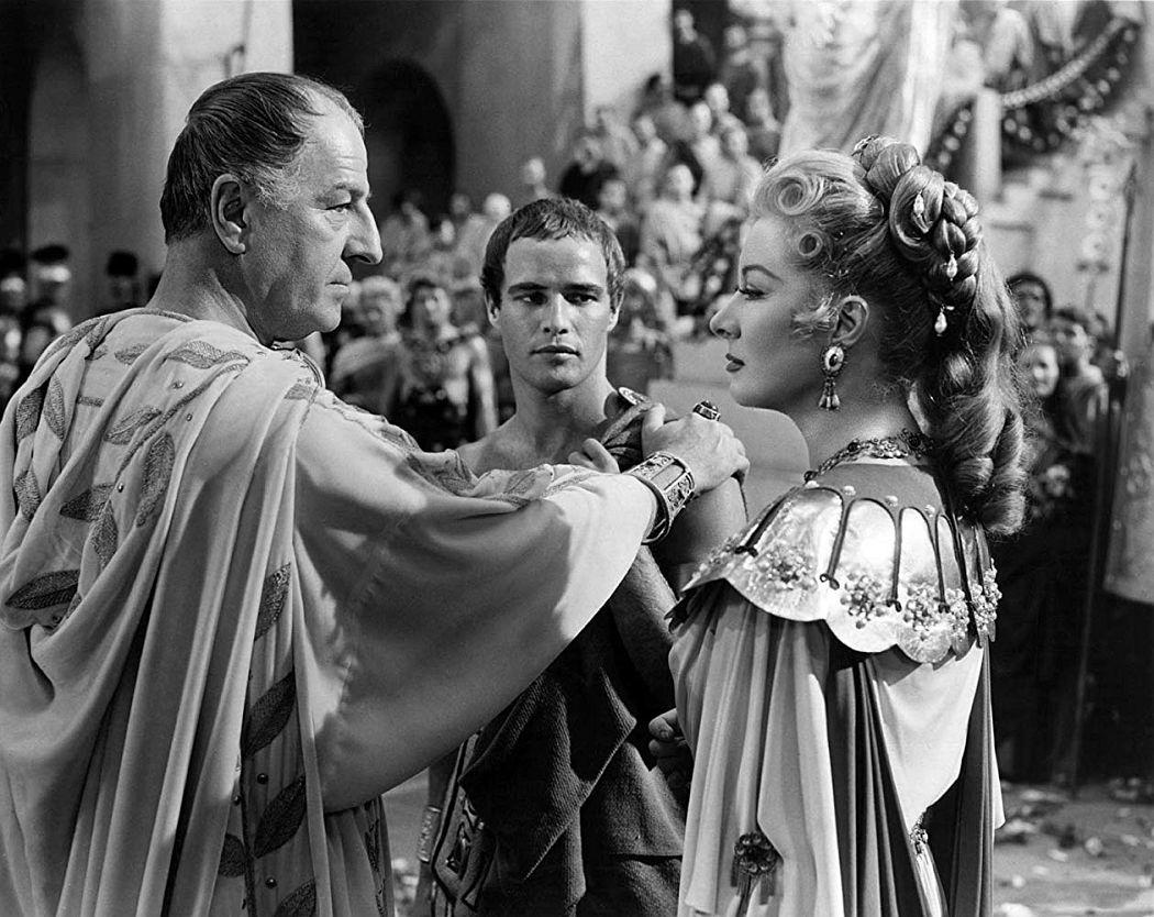 Marlon Brando interacting with his co-stars during a scene in Julius Caesar, showcasing his dominating presence.