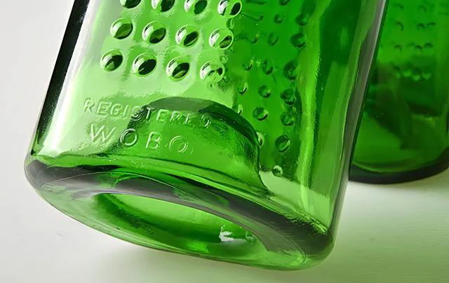 The bottle was designed to be stackable and interlocking, with a unique square shape and dimpled sides to help bond with mortar.