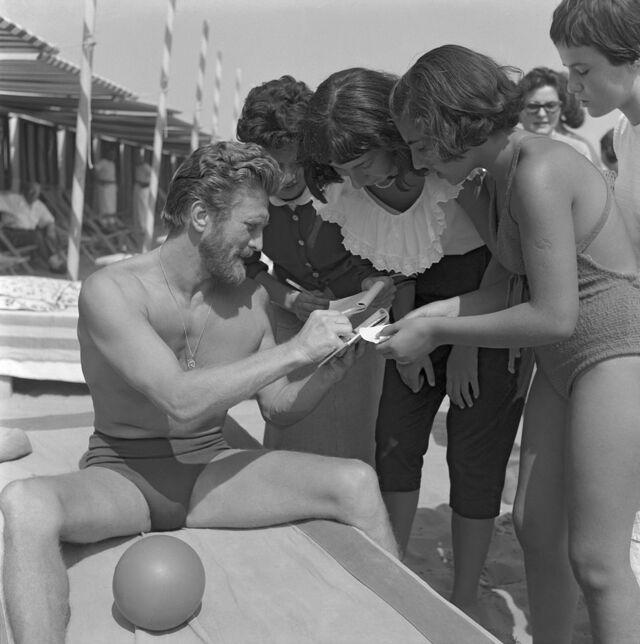 A timeless image of Kirk Douglas signing autographs for some female fans at Lido, Venice in 1953.