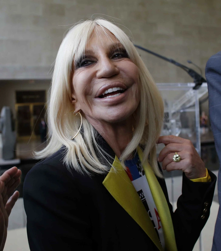 Donatella Versace beams with confidence, showcasing her iconic style.