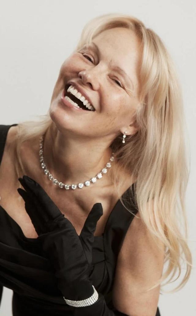 Pamela Anderson beams with joy, exuding confidence and charm in a chic black ensemble.