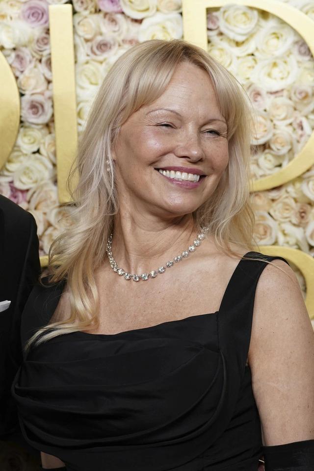 Pamela Anderson radiates elegance at a glamorous event, showcasing her timeless beauty.
