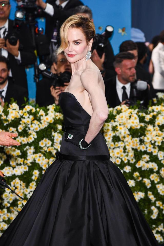 The dress featured a voluminous skirt with minimalist bow accents and layered evening gloves, perfectly complementing the daring pixie cut.