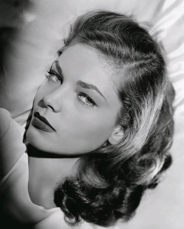Lauren Bacall seated atop a piano during a rehearsal or intimate gathering, highlighting her multifaceted talents beyond acting.