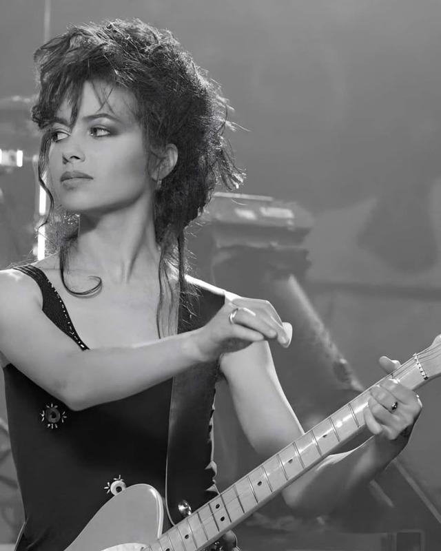 A mix of grace and strength—Susanna Hoffs captured in an artful performance, exuding the confidence of a true music icon.