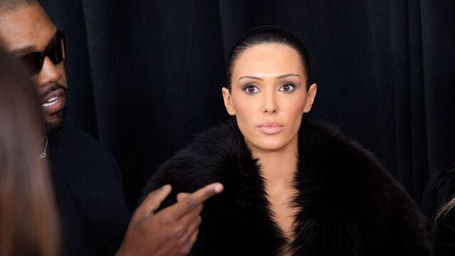 Bianca Censori exudes confidence alongside Kanye West at a fashion event, capturing the attention of the cameras.