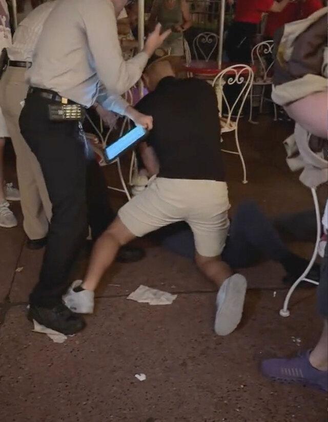 Bystanders and Disney staff restraining the suspect at the scene.