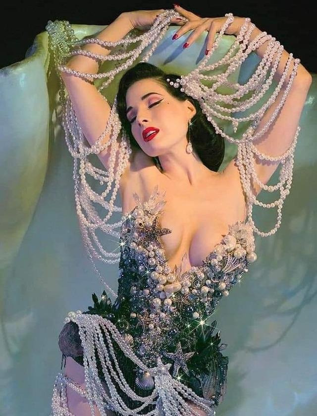 Dita Von Teese captivates in a luxurious pearl-covered costume, blending vintage allure with modern opulence.