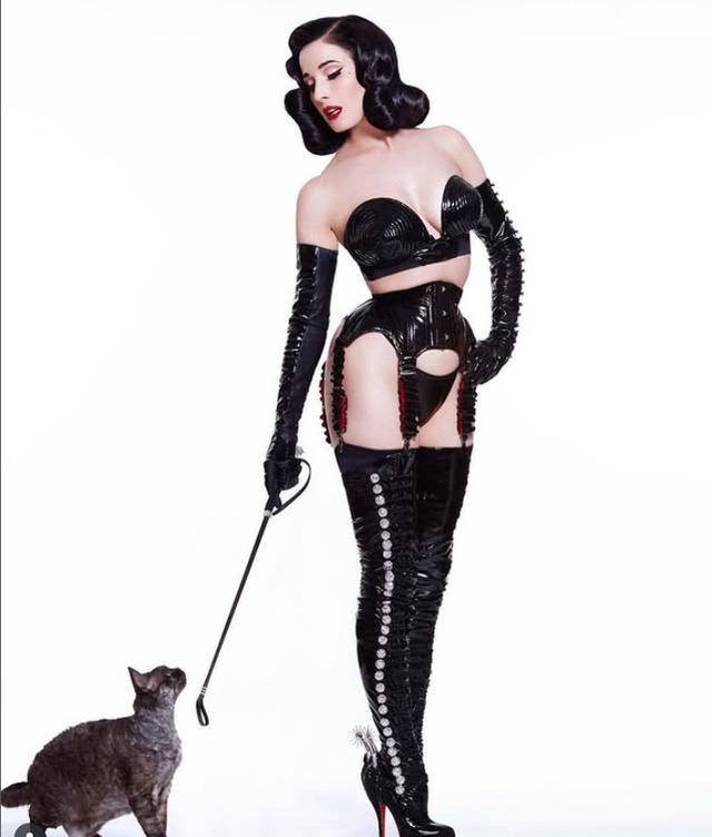 Dita exudes dark elegance with a commanding presence, wearing glossy latex and captivating everyone in her path.
