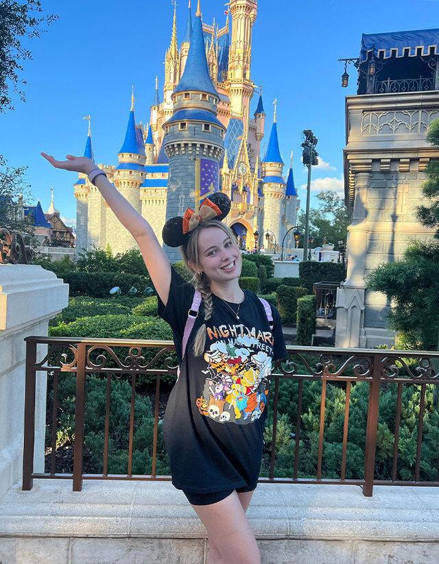 Sarah posing in front of Cinderella Castle, the iconic symbol of Magic Kingdom.