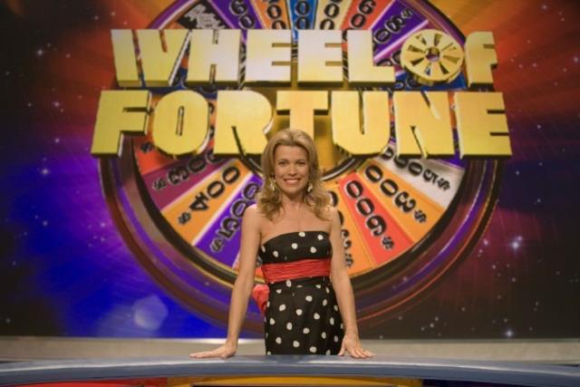 Vanna White at the Wheel of Fortune stage, standing proudly beside the iconic puzzle board.favorite.