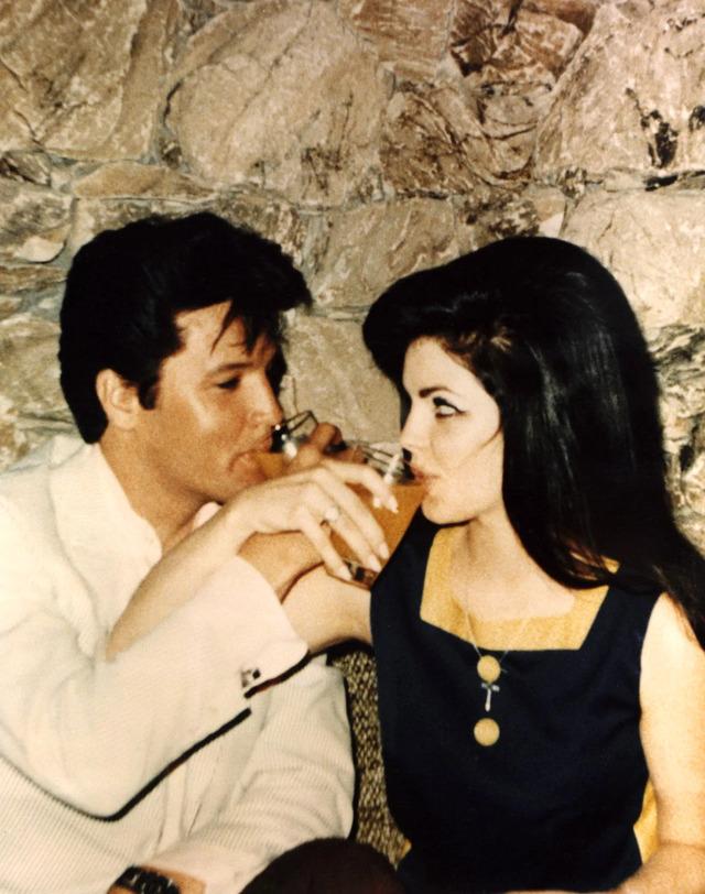 An intimate moment shared between Elvis Presley and Priscilla Presley, capturing the deep affection between the couple as they enjoy a private moment together.