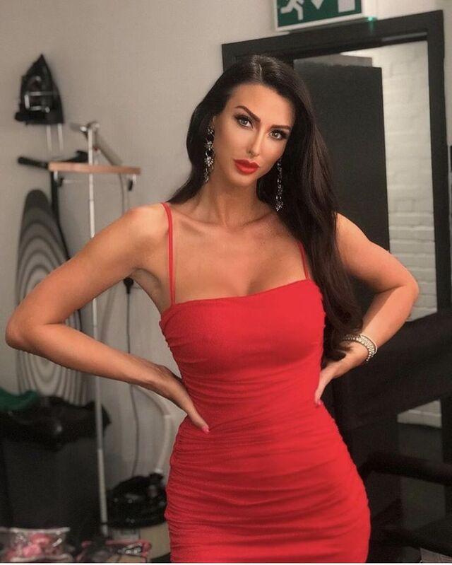 Looking bold and beautiful, Alice radiates confidence in this striking red dress, proving that she can shine in any setting.