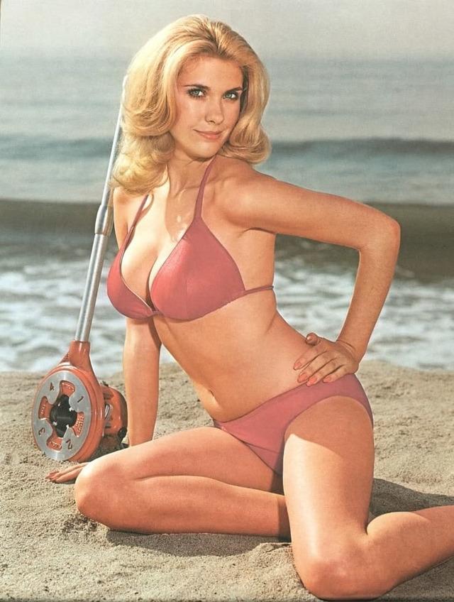 A stunning image of Colleen Camp from the '70s, radiating confidence with her playful smile and beachside allure