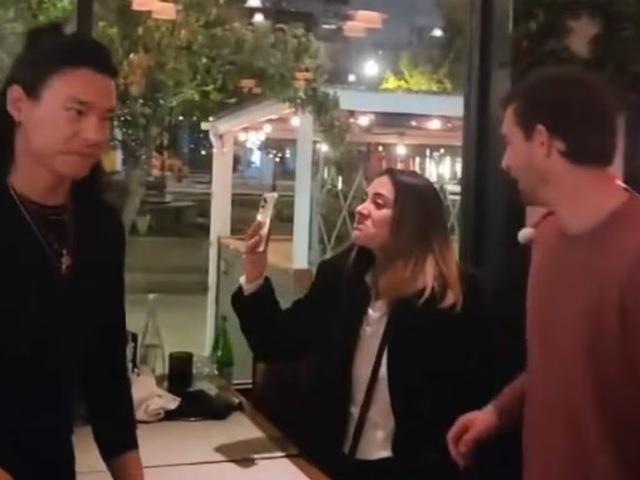 A tense moment as the intoxicated woman films the confrontation, displaying her displeasure.