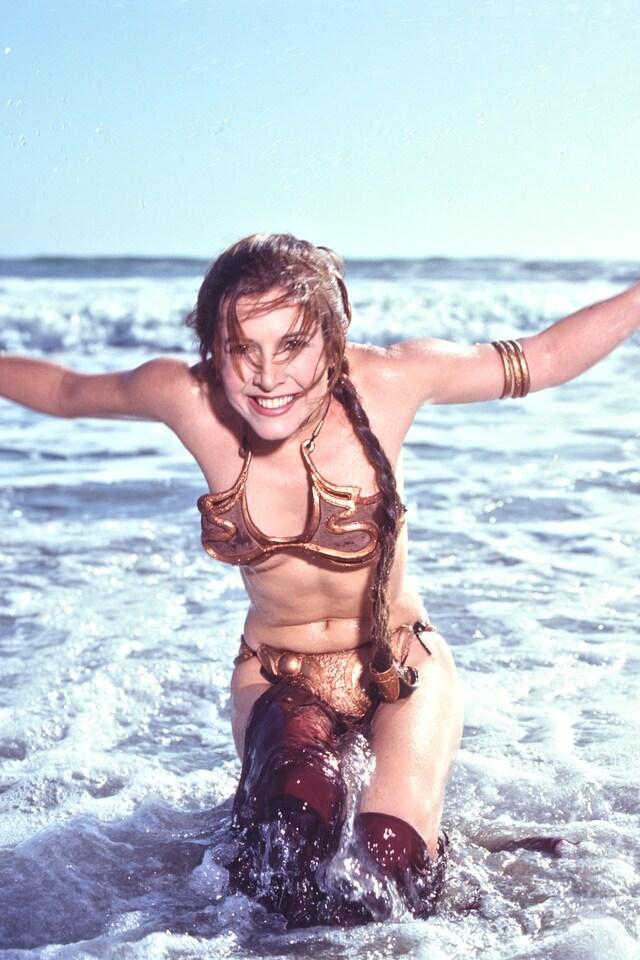 Carrie Fisher laughing in the iconic slave Leia bikini scene from Return of the Jedi. 