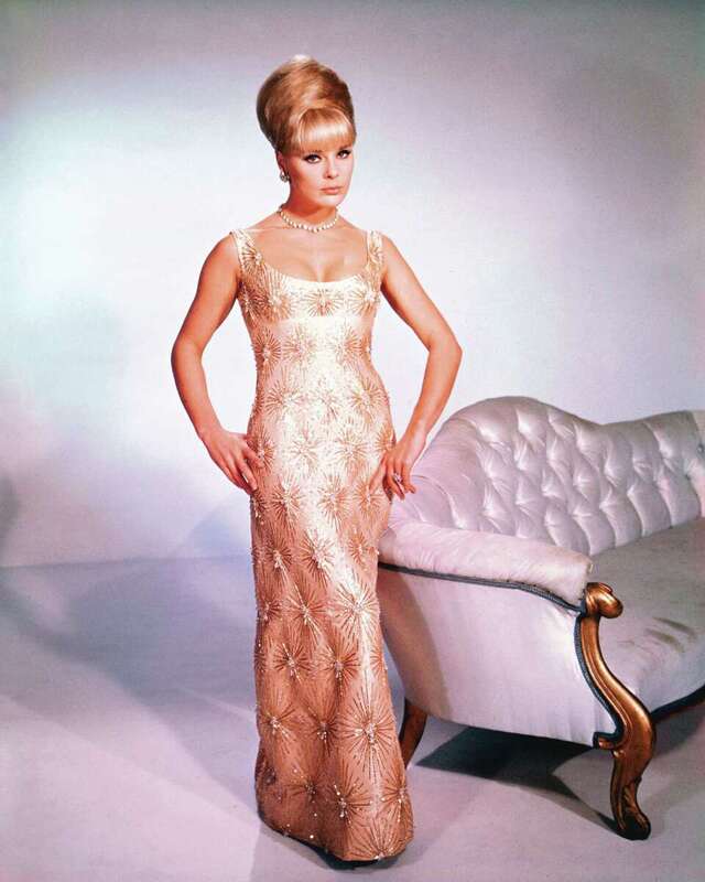 Elke Sommer exudes timeless elegance in this iconic shot, wearing a stunning gold gown. The glamorous look highlights her ability to captivate audiences both on-screen and in fashion.