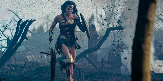 In this pivotal scene, Diana steps onto a battlefield, deflecting bullets with her shield and charging forward into enemy fire.